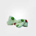 White bow-shaped toy with green and red accents on a light gray background