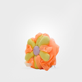 Floral hair clip with orange and green petals on a white background