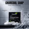 Fiabila Charcoal Soap box shown in a clean studio-style ad with water splashes and foam, plus large text reading 'CHARCOAL SOAP' and smaller product claims.
