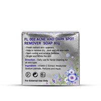 A square silver box of FL 002 Acne and Dark Spot Remover Soap 80g, featuring blue text and purple floral illustrations on a white background.