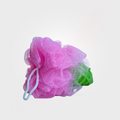 Pink bath pouf with a green mesh bag on a light gray background